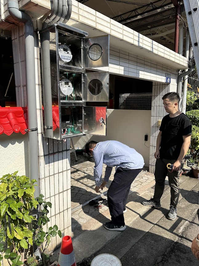 工作人員正在配置與安裝電表箱，電表箱為不鏽鋼材質
